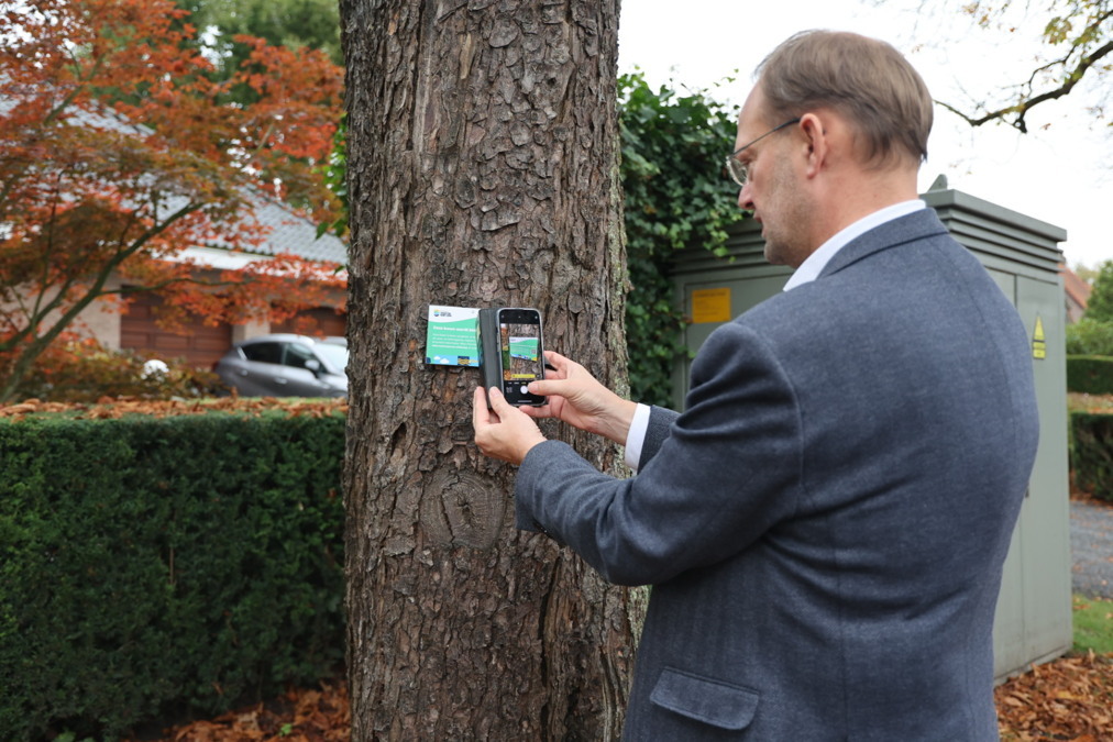 Wethouder-van-der-Kooi-scant-QR-code-op-bomen-bordje.jpeg