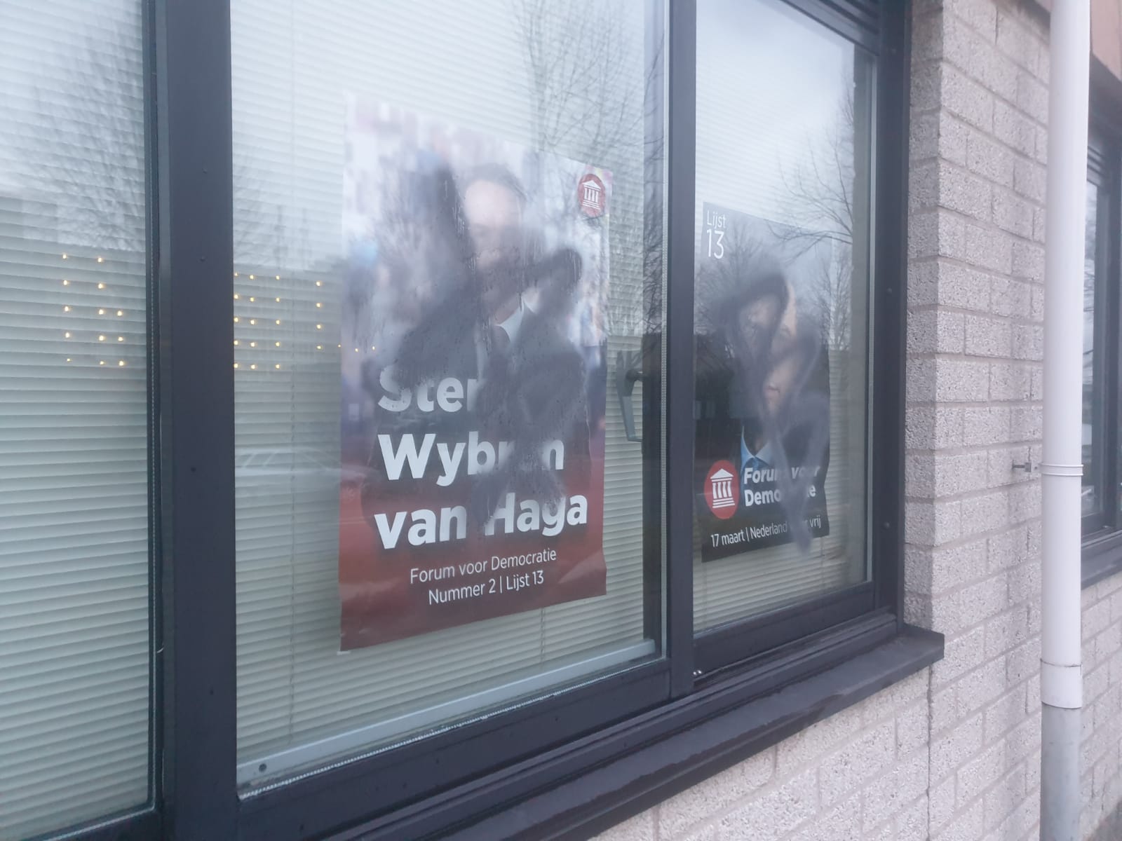 Woning met politieke posters achter het raam met verf beklad